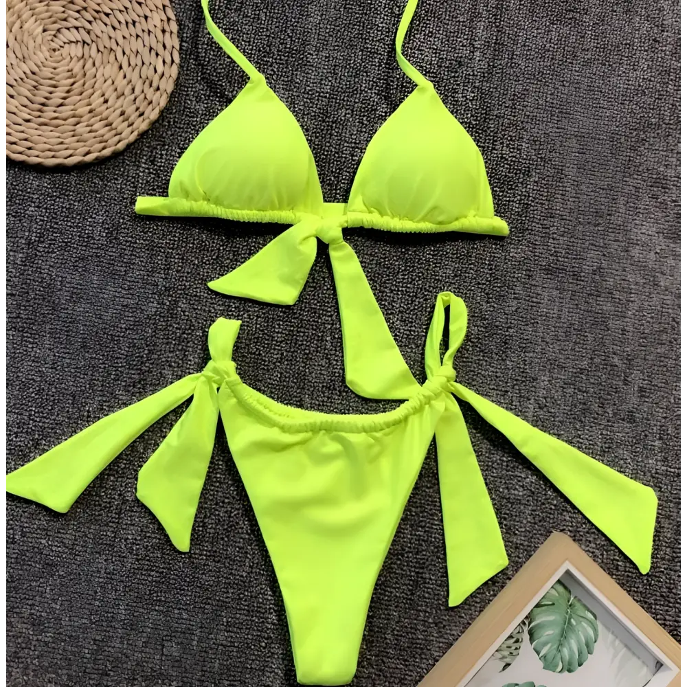 Lavender ruched split bikini swimsuit featuring a bright neon green triangle top with tied side bow details