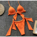 Bright orange split bikini swimsuit with tied bow details on top and bottom featuring a lavender ruched design