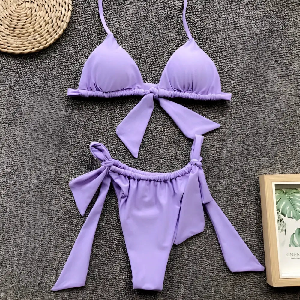 Lavender ruched triangle split bikini swimsuit with tied bow details on top and bottom pieces for stylish swimwear