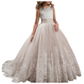 A woman wears an elegant sleeveless lace wedding dress in champagne with lavender tulle lace detailing