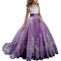 A young woman wears a lavender tulle lace wedding dress with an embellished white bodice and intricate skirt details