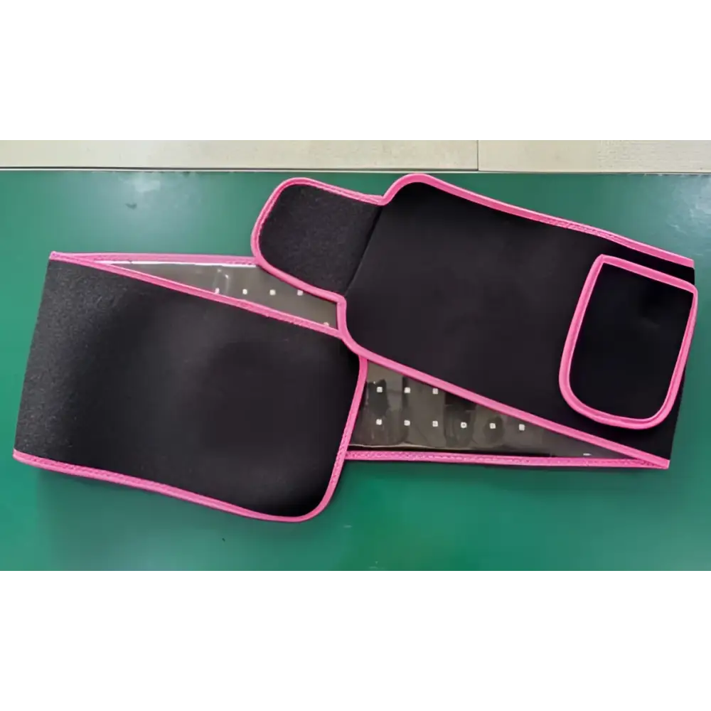 Black waist trainer with pink trim and mesh panel supporting led infrared belt therapy device with infrared heating red features