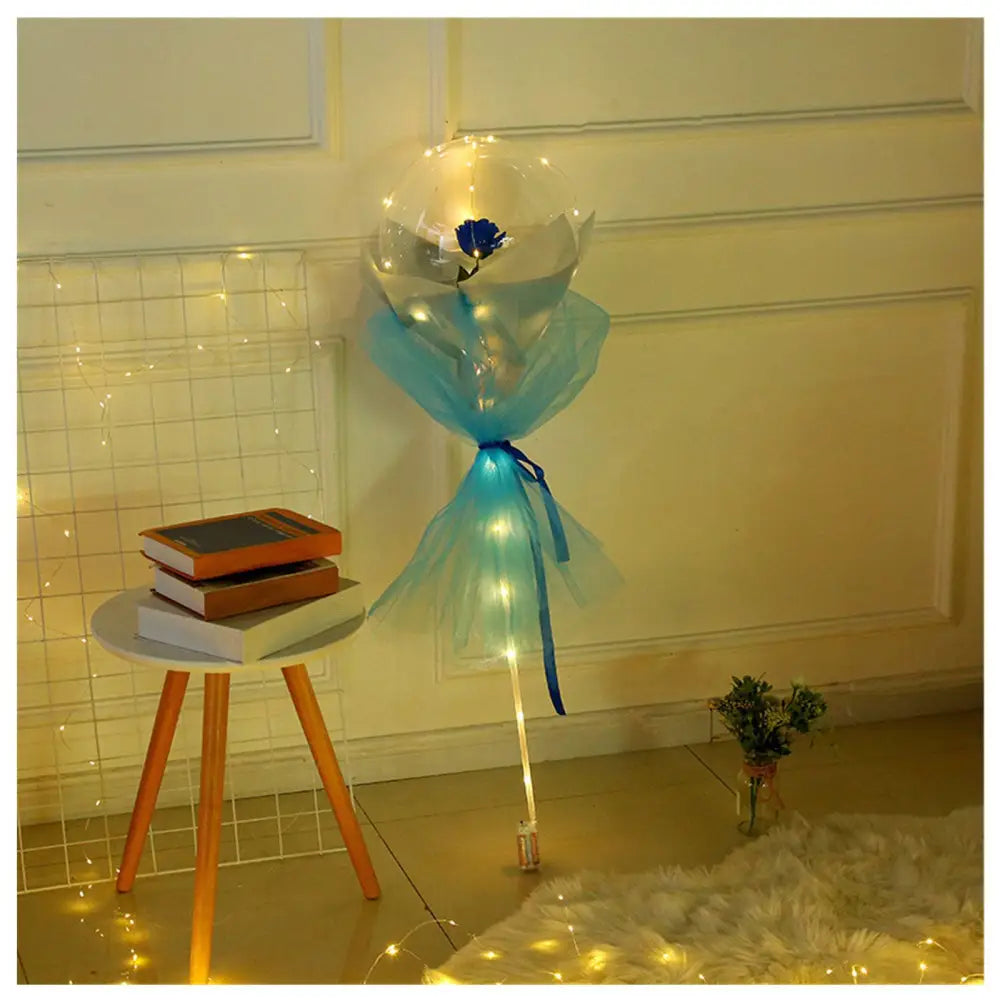 A luminous balloon rose bouquet featuring a transparent bobo ball with a blue rose wrapped in light-blue tulle and ribbon