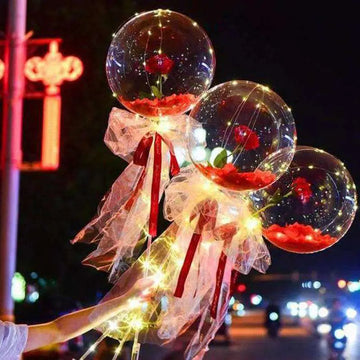 Transparent bobo ball featuring a luminous balloon rose bouquet with red roses and glowing LED lights inside