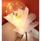 A delicate white flower inside a transparent bobo ball luminous balloon rose wrapped in sheer tulle with warm lights