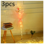 A luminous balloon rose bouquet featuring a pink rose inside a transparent bobo ball wrapped in peach tulle with string lights