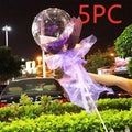A transparent bobo ball containing a single purple luminous balloon rose wrapped in lavender organza with ribbon ties