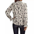 Women’s leopard print long sleeve turtleneck shirt with black and white abstract animal print and ruffled cuffs and neckline