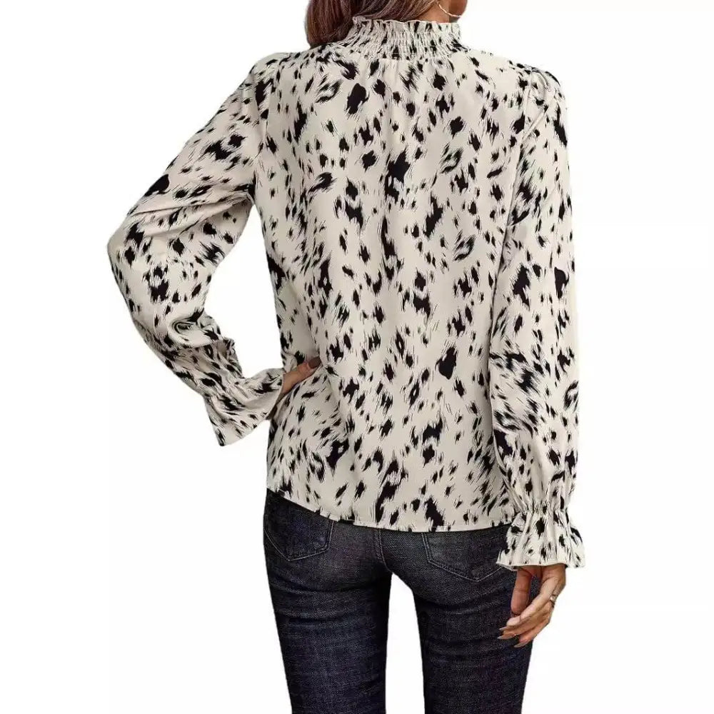 Women’s leopard print long sleeve turtleneck shirt with black and white abstract animal print and ruffled cuffs and neckline