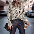 A leopard print long sleeve turtleneck shirt in black and cream with ruffled cuffs for elegant wear