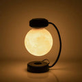 Levitating led moon night light with warm glow suspended by magnetic base above black curved stand