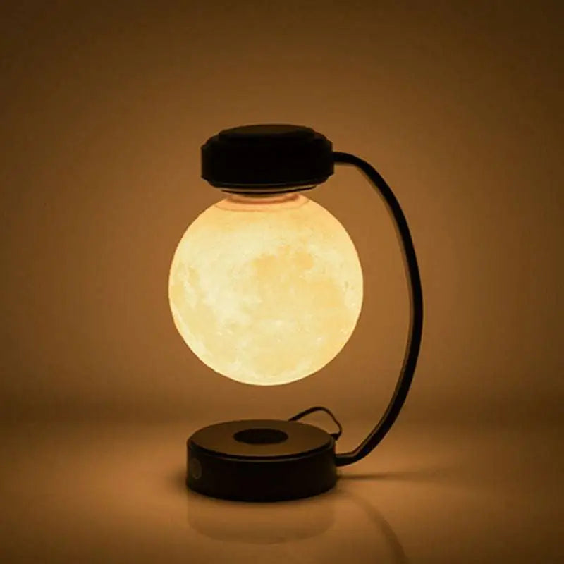 Levitating led moon night light with warm glow suspended by magnetic base above black curved stand