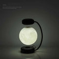 Levitating led moon night light with magnetic base and realistic lunar surface on black wireless night light stand