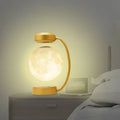 Golden levitating led moon night light with magnetic base featuring a translucent illuminated lunar surface