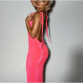 Vibrant pink slim backless dress with thin tie straps and textured fabric shown from the back side