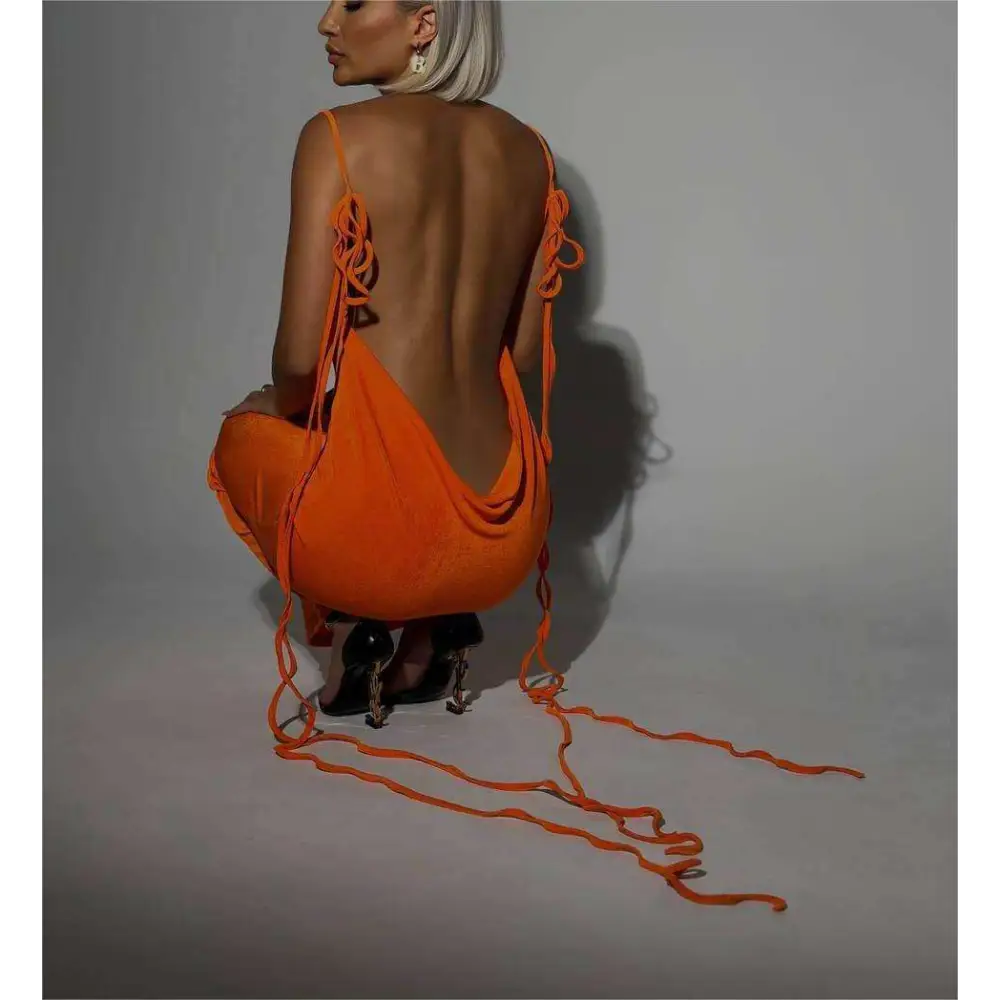 Back view of a vibrant orange slim backless dress summer gown with thin straps tied in decorative knots along the spine