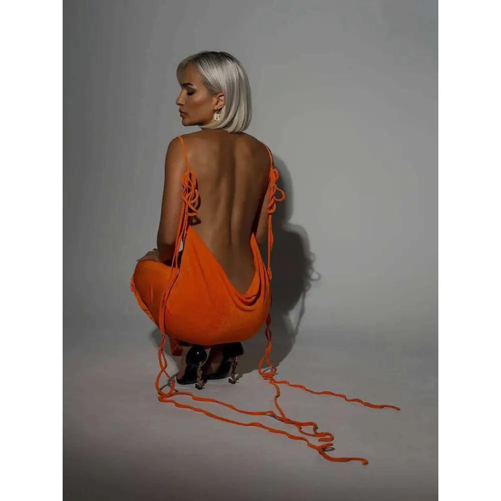 Back side of a vibrant orange slim backless dress with thin straps tied in decorative knots, perfect as a dress summer gown
