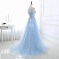 A light blue slim fit bridesmaid gown with silver beading features intricate lace and a flowing tulle skirt