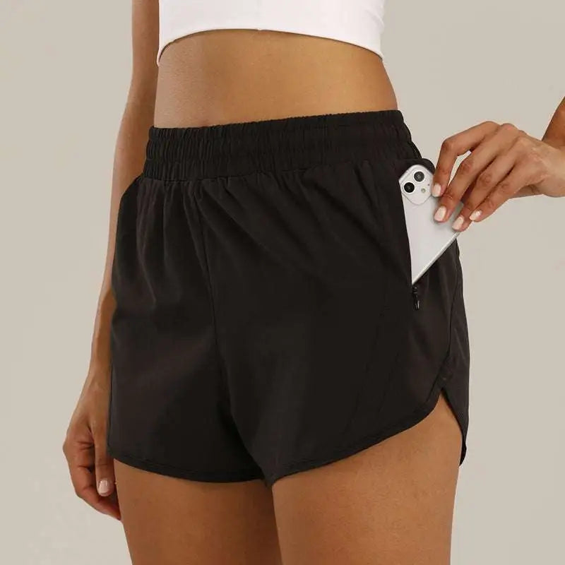 Black athletic summer sports shorts with elastic waistband and breathable zipper pockets holding a smartphone