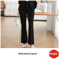 Black bootcut pants with tailored fit and subtle side slits complementing a light blue tailored business suit with gold buttons