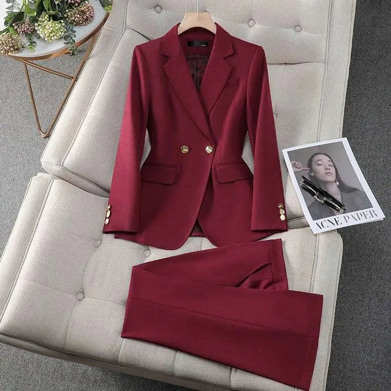 A tailored business suit featuring a sleek wine red blazer with gold buttons and matching trousers for formal wear