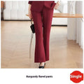 Burgundy flared pants with smooth tailored fabric and clean seams complementing light blue tailored business suit with gold buttons