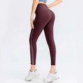 Maroon seamless high waisted lifting workout leggings with vertical side panel made from stretchy athletic fabric