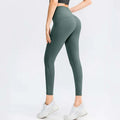 A pair of seamless high waisted lifting workout leggings in solid sage green with subtle side seam detailing