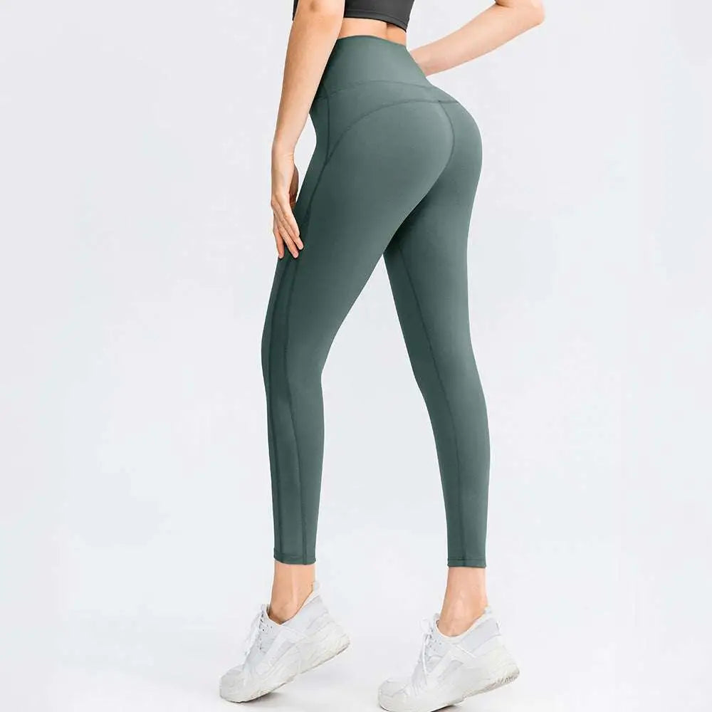 A pair of seamless high waisted lifting workout leggings in solid sage green with subtle side seam detailing