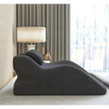 Black plush ergonomic lounge chair with sleek modern design paired with light green reclining stomach sleeper pillow