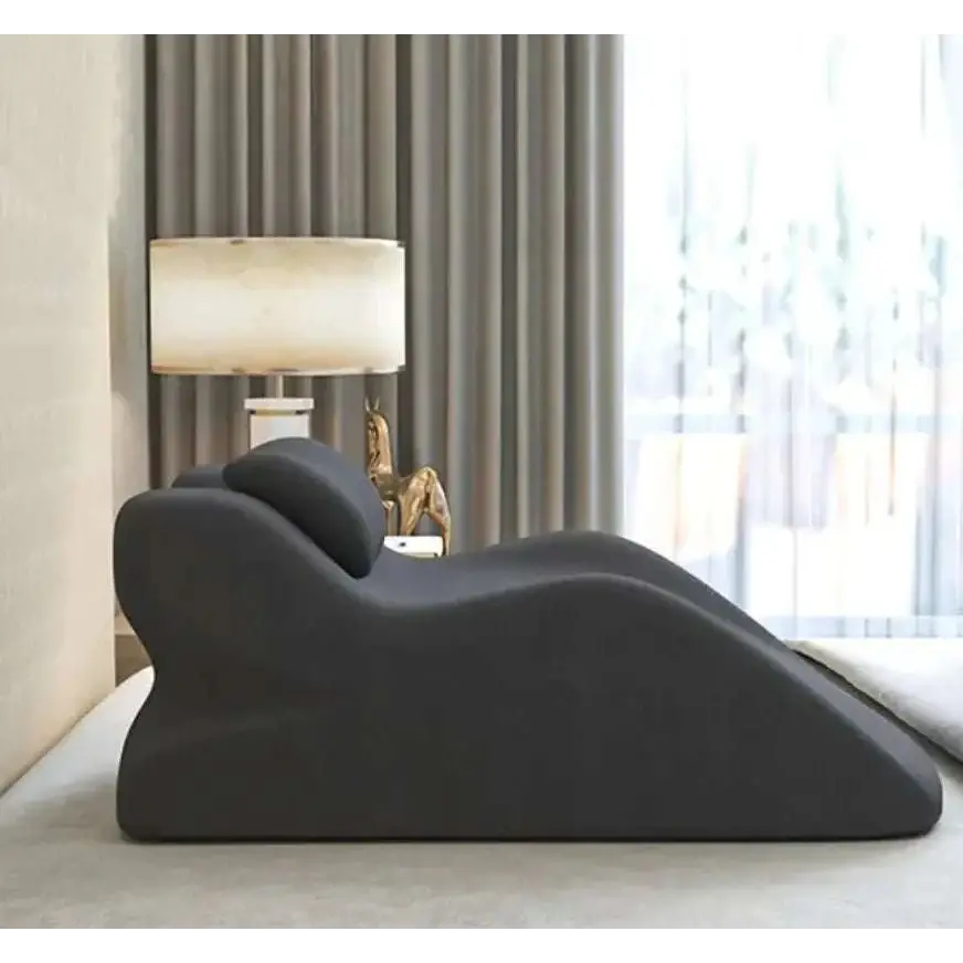 Black plush ergonomic lounge chair with sleek modern design paired with light green reclining stomach sleeper pillow