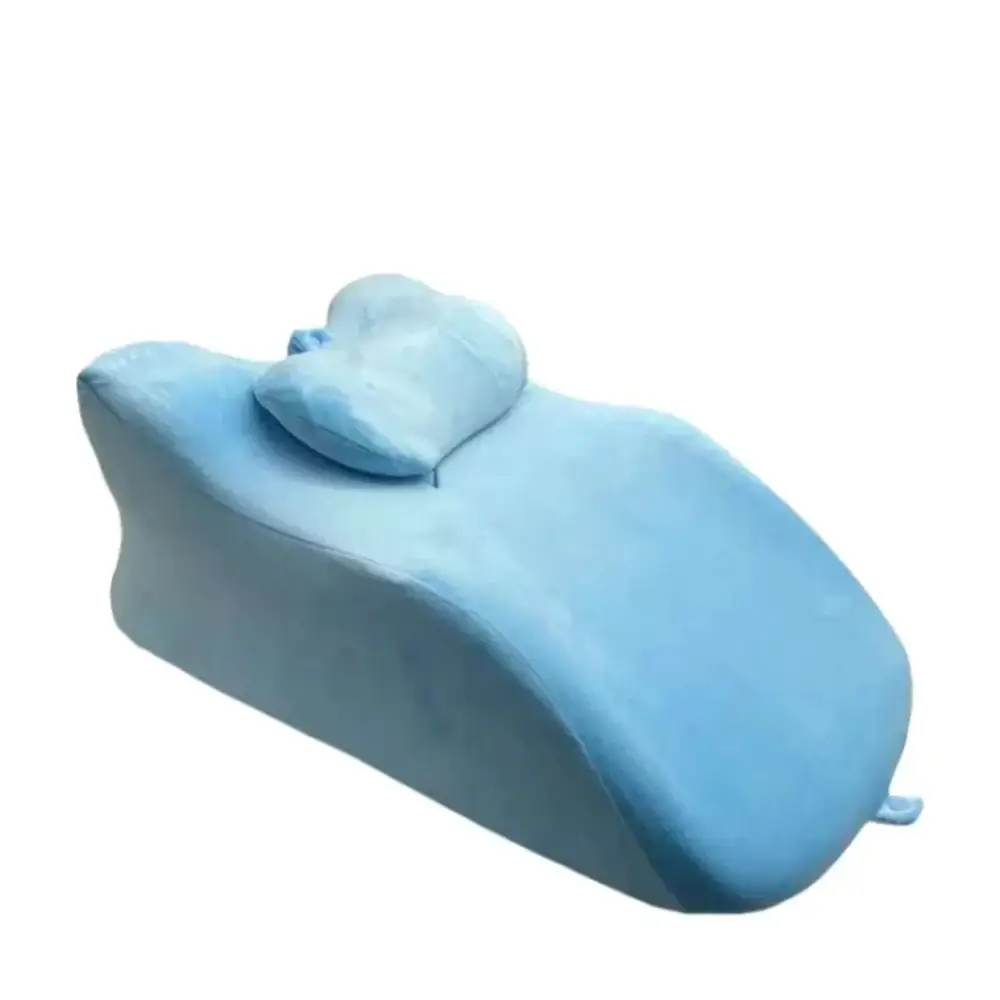 Light blue plush memory foam stomach sleeper pillow with contoured design on light green reclining chair