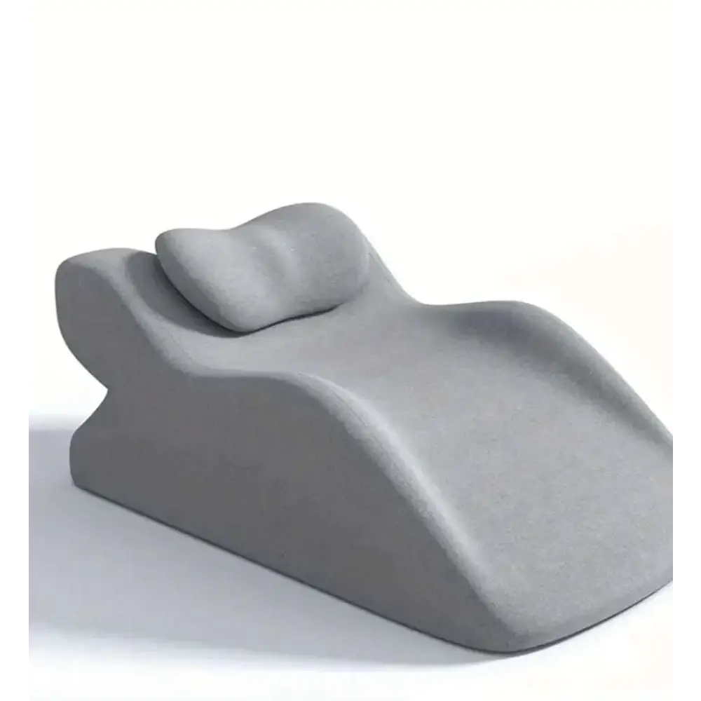 Gray ergonomic recliner with smooth molded design and integrated headrest featured in light green reclining chair with stomach sleeper pillow