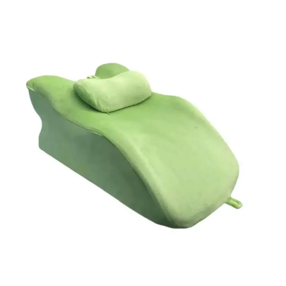 Light green reclining chair with plush fabric and matching stomach sleeper pillow for comfortable relaxation