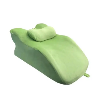 Light green reclining chair with plush fabric and matching stomach sleeper pillow for comfortable relaxation