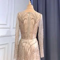 Shimmering luxury minority champagne beaded evening gown with long sheer sleeves and intricate gold back detailing