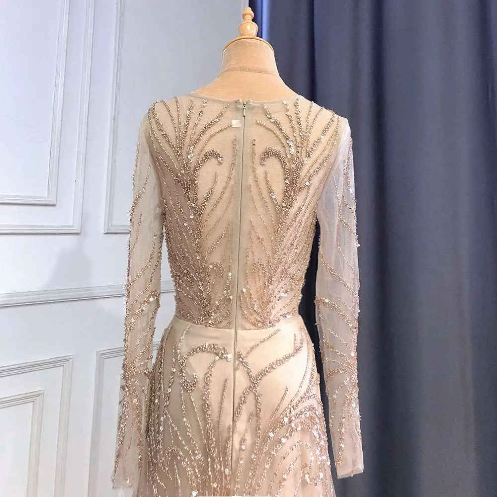 Shimmering luxury minority champagne beaded evening gown with long sheer sleeves and intricate gold back detailing