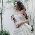 White strapless light wedding gown with ruched bodice and flowing skirt in a short elegant design