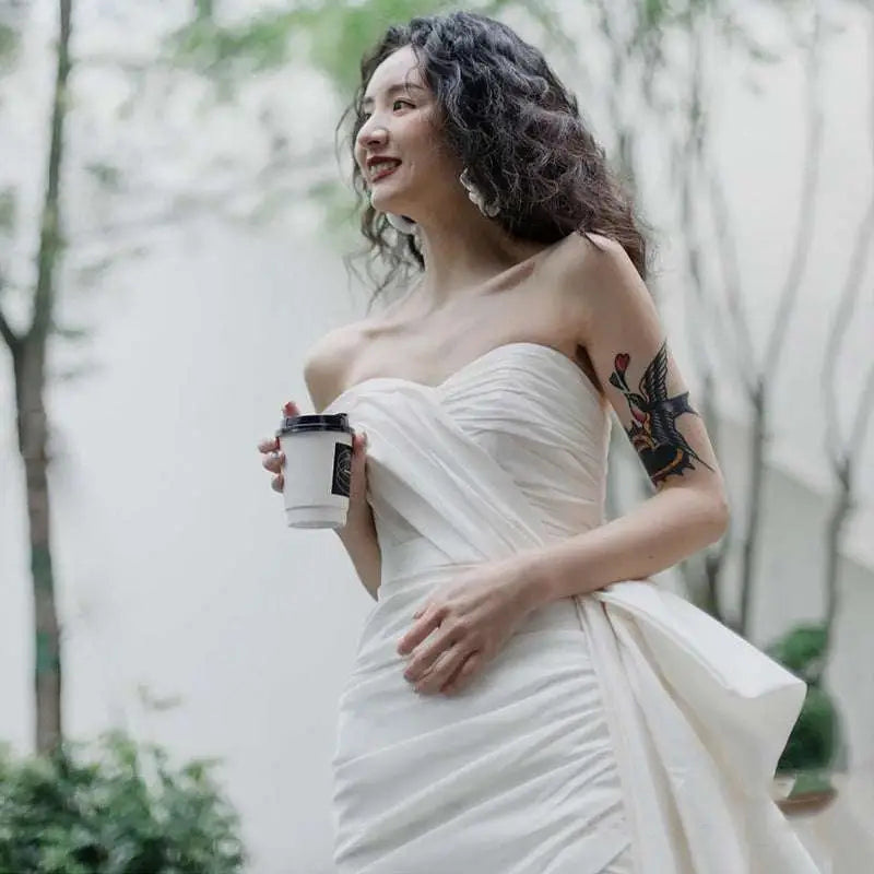 White strapless light wedding gown with ruched bodice and flowing skirt in a short elegant design
