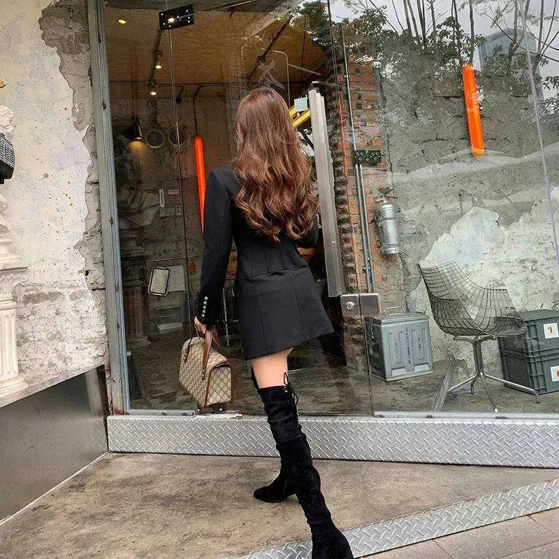 Black velvet over-the-knee boot paired with a black gold button blazer dress featuring a gold button blazer style