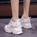 White chunky platform casual sports single sneakers with lime green mesh and synthetic overlays and sculpted sole design