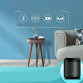 Black cylindrical smart speaker with glowing blue light on gray textured fabric log color smart side table with wireless charging