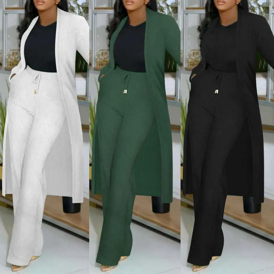 A plus-size woman wearing a long cardigan sunken stripe set with wide leg pants in white green and black