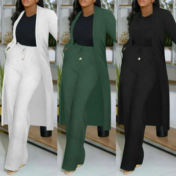 A plus-size woman wearing a long cardigan sunken stripe set with wide leg pants in white green and black