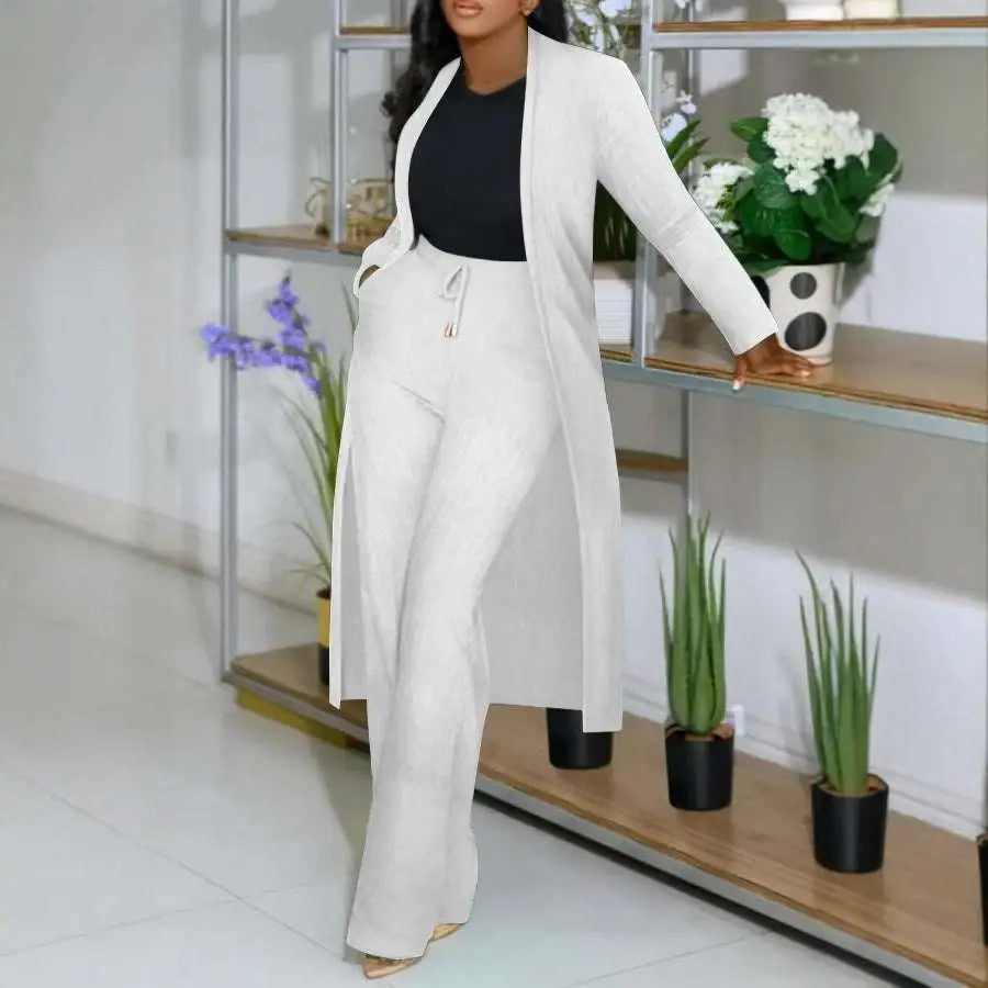 A plus-size woman wearing a long cardigan sunken stripe set with wide leg pants in white green and black