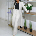 White longline cardigan sunken stripe with relaxed fit and subtle texture worn over black top and wide leg pants