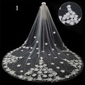 Long lace wedding veil in sheer white lace featuring intricate floral embroidery along edges and cascading length