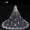 Long lace wedding veil with delicate white lace and intricate floral embroidery displayed on a mannequin