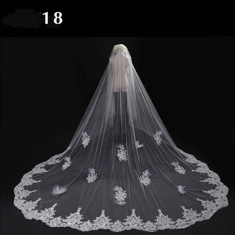 Long lace wedding veil with delicate white lace and intricate floral embroidery displayed on a mannequin