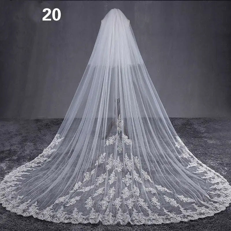 Long lace wedding veil with delicate white lace and intricate floral embroidery along the hemline